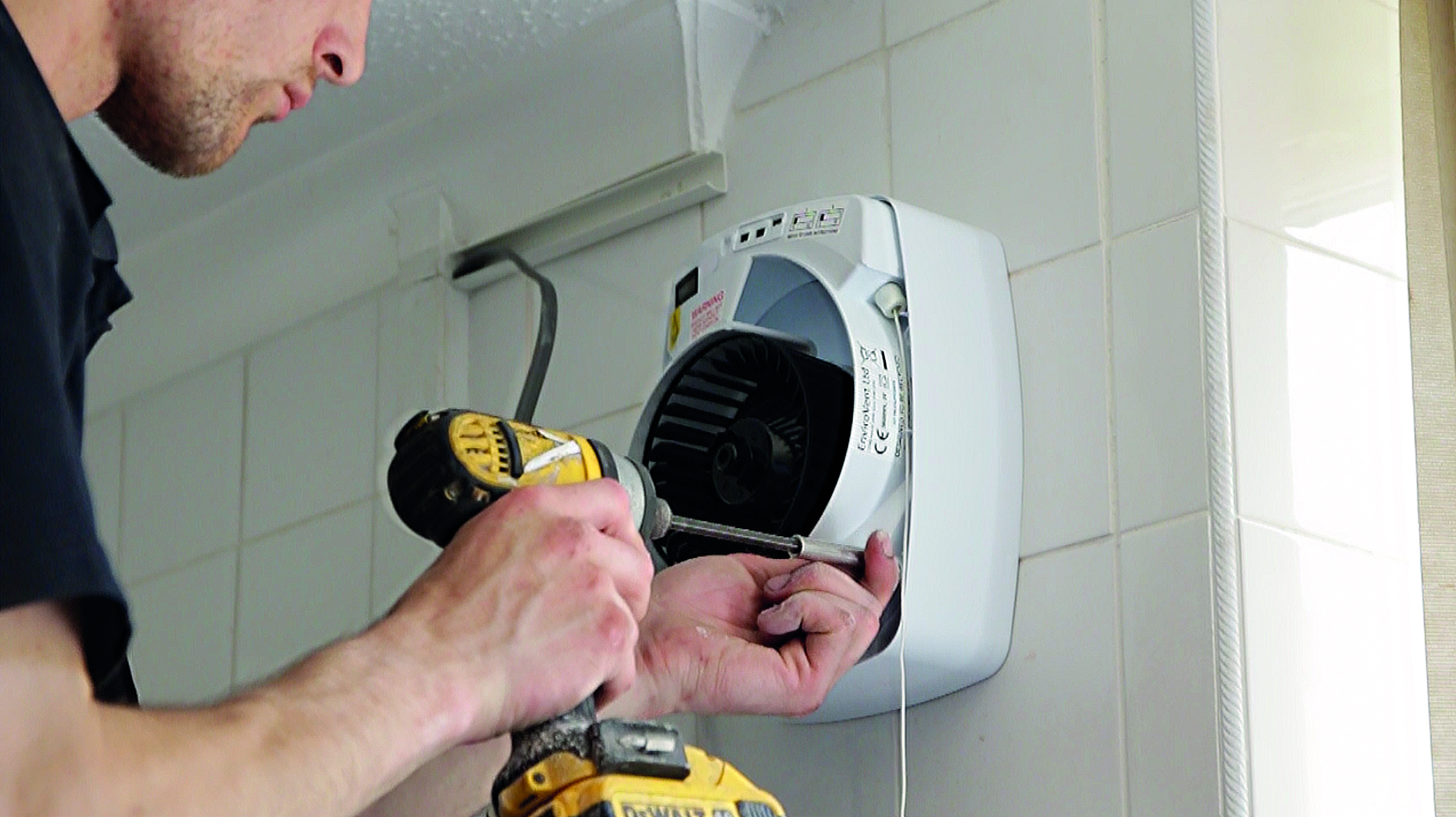 man-installing-infinity-extractor-fan-in-wall